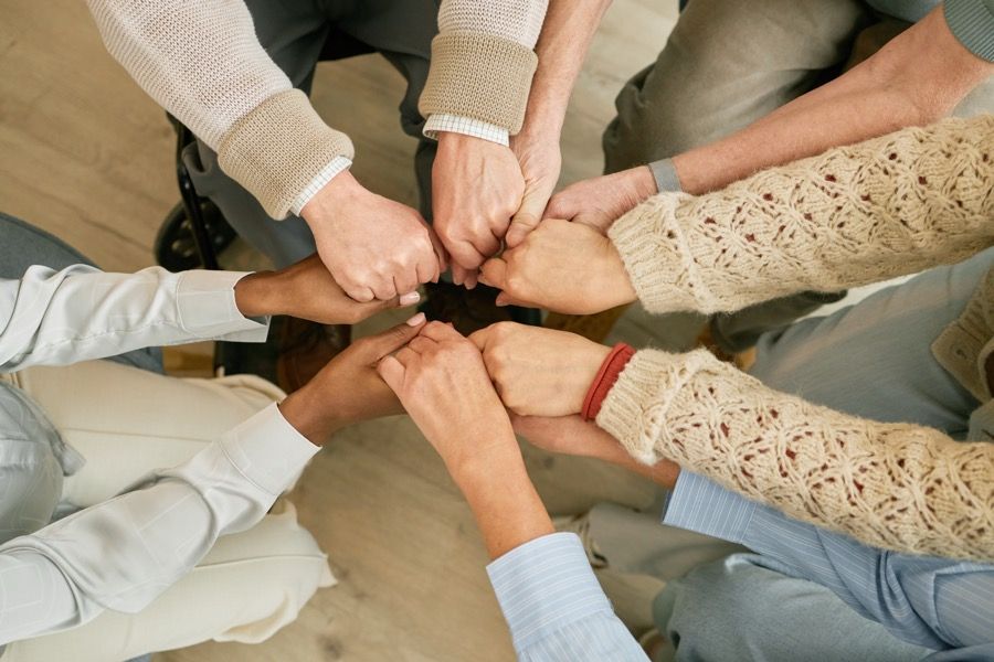 Hände eines Teams, die sich in der Mitte treffen